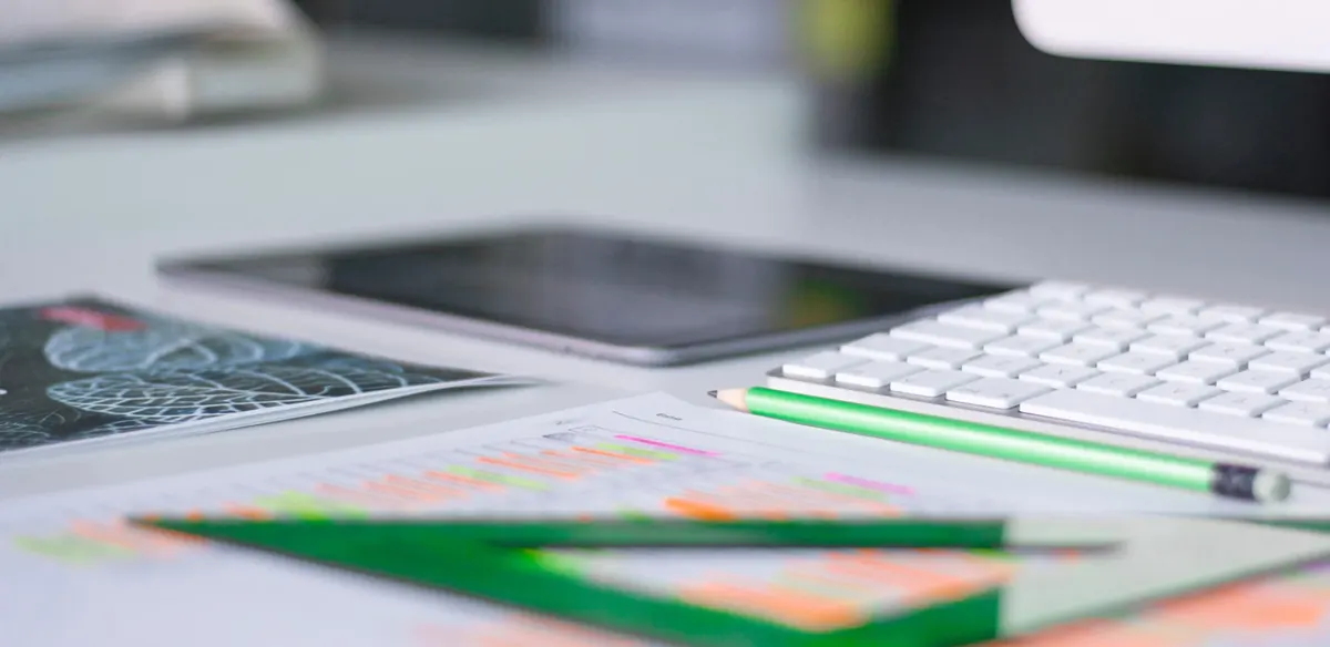 Tastatur, Tablet und Planunterlagen auf einem Arbeitstisch